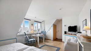 A bedroom with a bed, a desk, a chair, a television, and a window. - Holiday Apartment 'Haus Lazy Dolphin No. 10' with Sea View and Wi-Fi (Rantum)