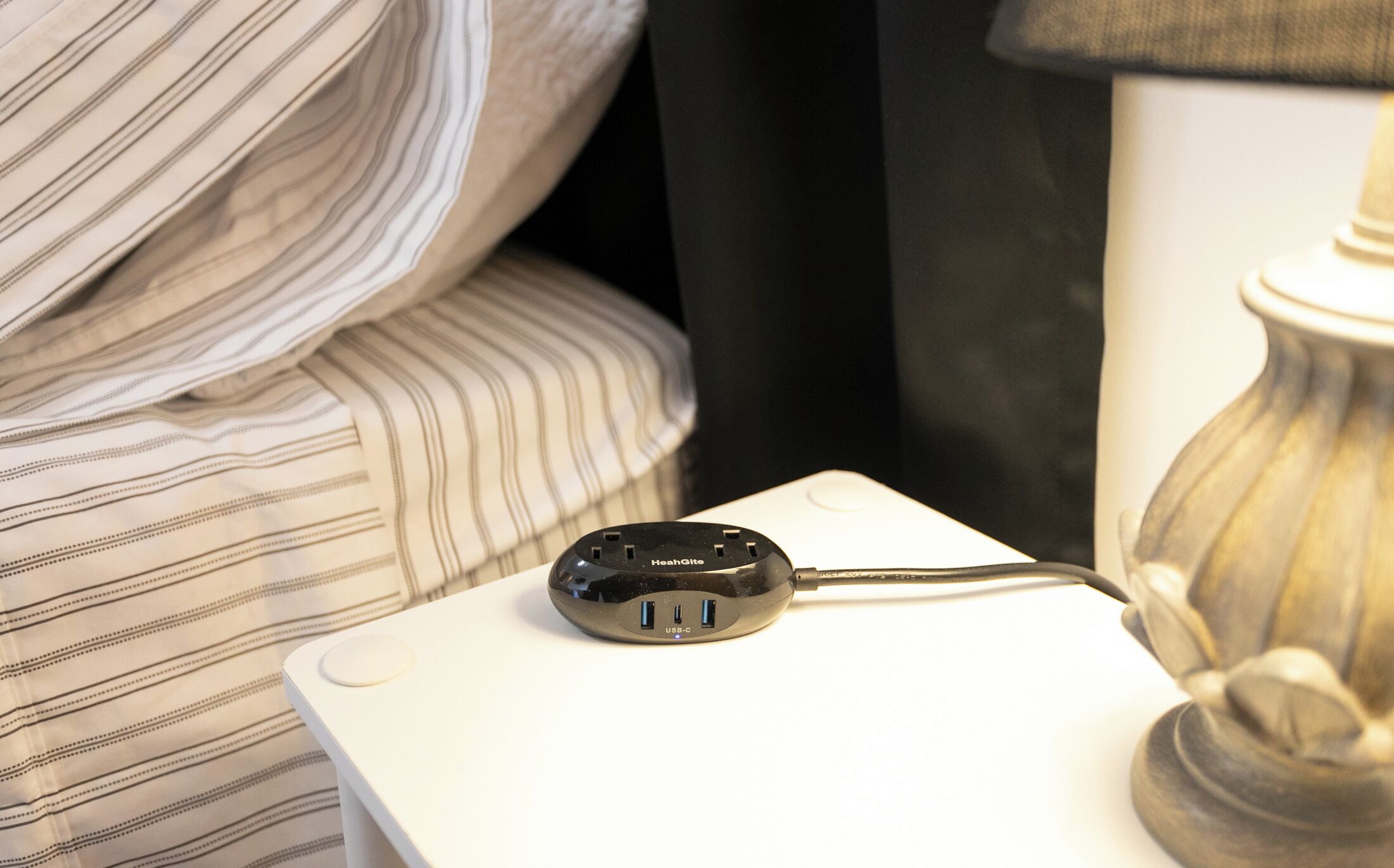 A USB-C charging port on a white bedside table.