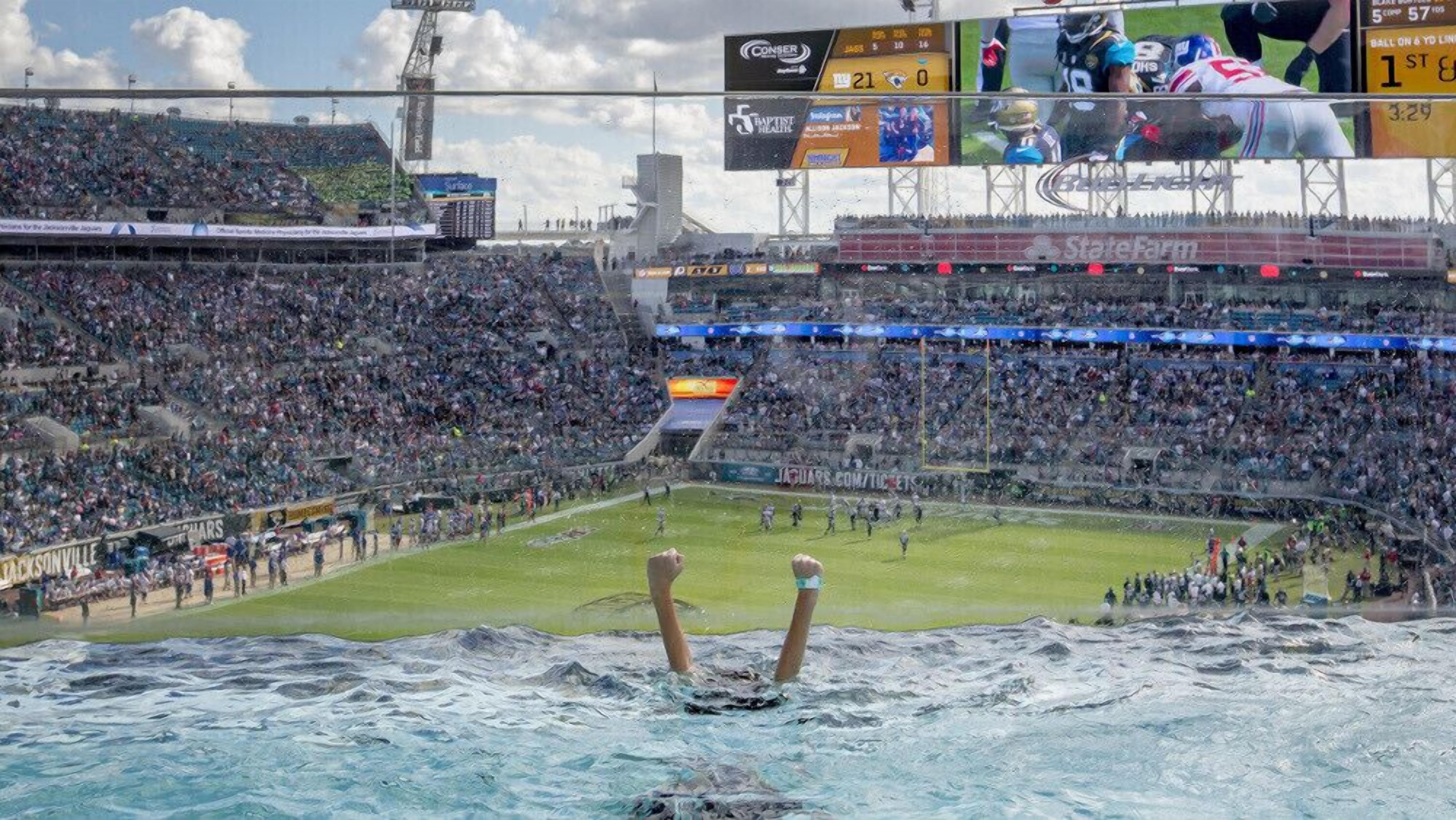 Un estadio con múltiples niveles de asientos, un marcador y un campo de juego visible.