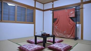 Traditional Japanese room with tatami flooring, featuring a tatami mat table and seating area.
