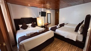A hotel room with two beds, wooden flooring, a flat-screen TV, and a bedside table with a lamp. - SAYACMARCA CLASSIC INN (Machu Picchu)
