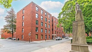 A red brick building with a statue in front. - Winkley House by Guestz (Preston)