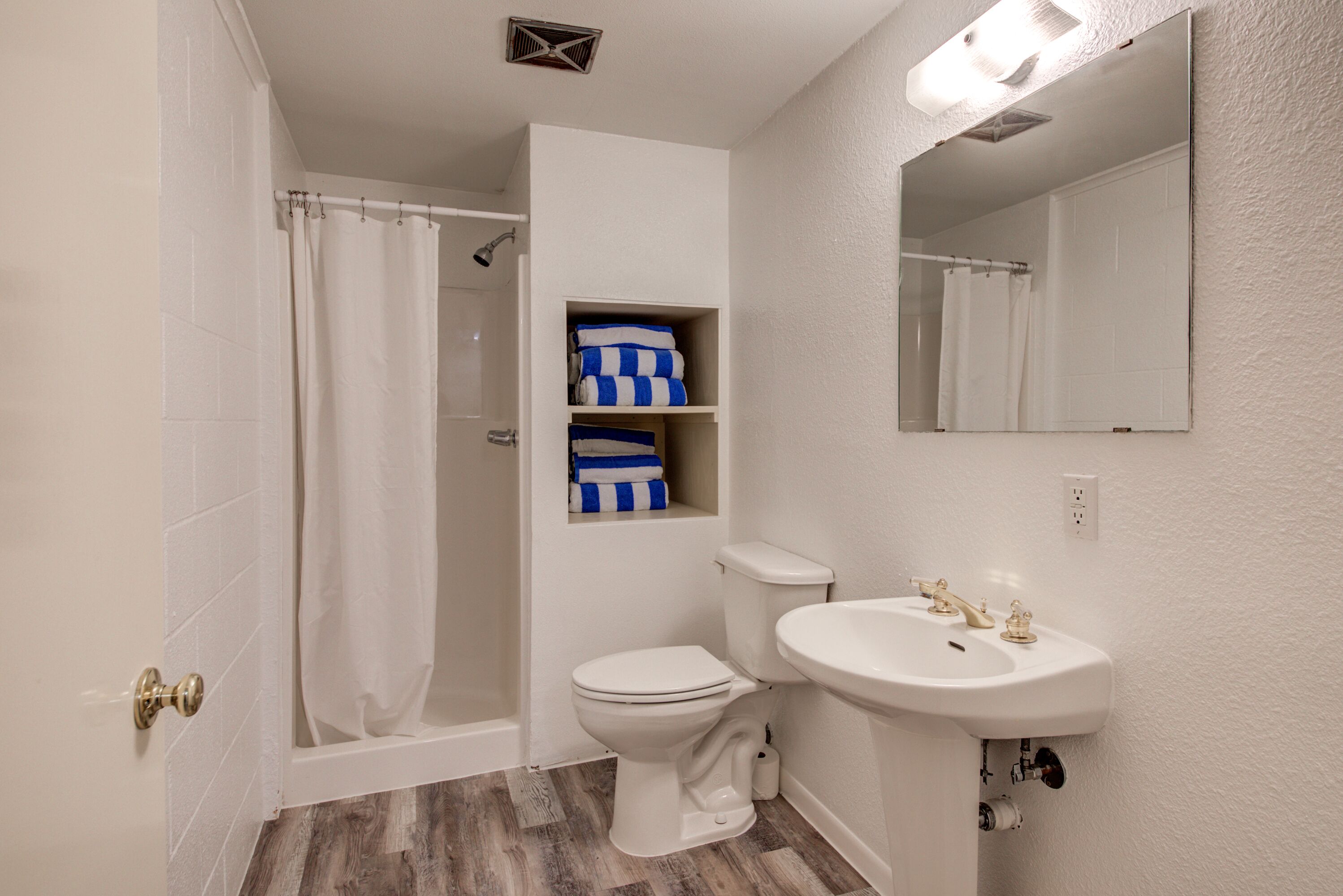 A bathroom with a shower, toilet, and sink.