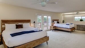 A bedroom with two beds, a ceiling fan, a desk, and a window with a view. - 🌵 Austin Escape with Private Pool, Ping Pong & Game Space | Roadrunner Retreat (Austin)