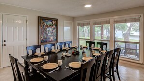 A dining room with a large table set for a meal, chairs around it, and a painting on the wall. - 🌵 Austin Escape with Private Pool, Ping Pong & Game Space | Roadrunner Retreat (Austin)