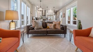 A spacious living room with a sofa set, a coffee table, and a lamp.