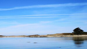 A calm coastal scene with a lighthouse, sandy beach, and a clear blue sky. - Spacious house 200m from Lilia's beaches & restaurants (Plouguerneau)