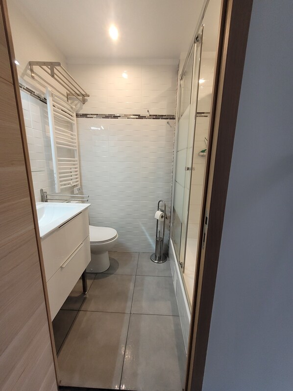 Une salle de bain moderne équipée de toilettes, d’un lavabo et d’une douche.