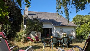 An outdoor patio with folding chairs, a table, and a bottle of beer. - Large family home, between beaches and marshes. (Mesquer)