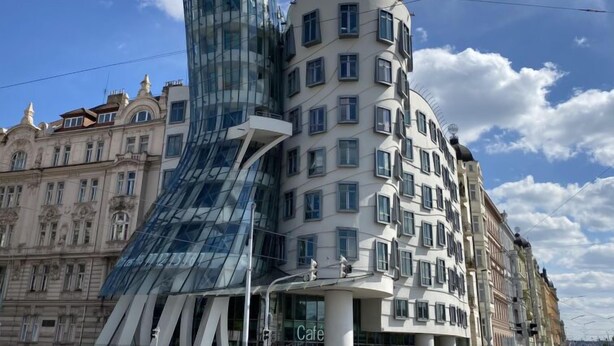 Un bâtiment moderne doté d’une façade en verre et un bâtiment traditionnel avec de nombreuses fenêtres.