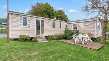 A mobile home with a patio area and outdoor seating.