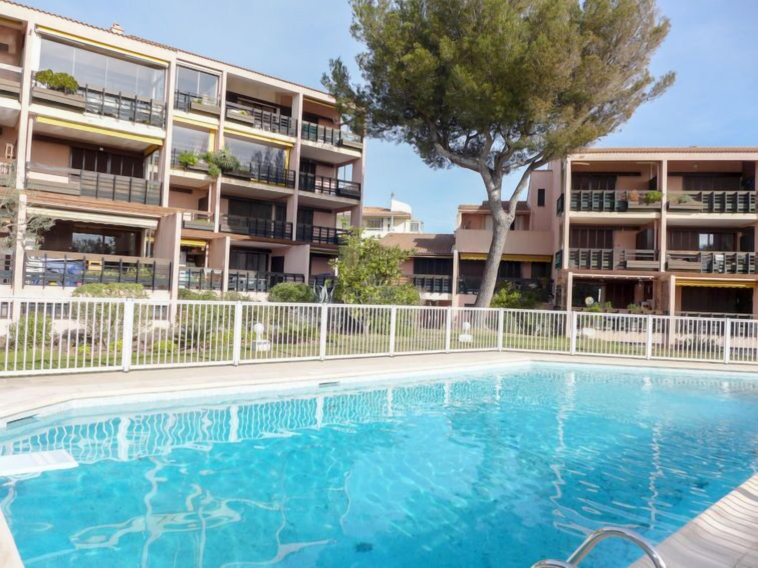 Un edificio moderno con varios balcones y una piscina.