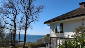 A house with a view of a lake, a patio with chairs, and a garden. - Villa Hjartnes by Interhome (Baldersheim)