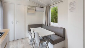 Una habitación compacta con kitchenette, una mesa de comedor y zona de estar.