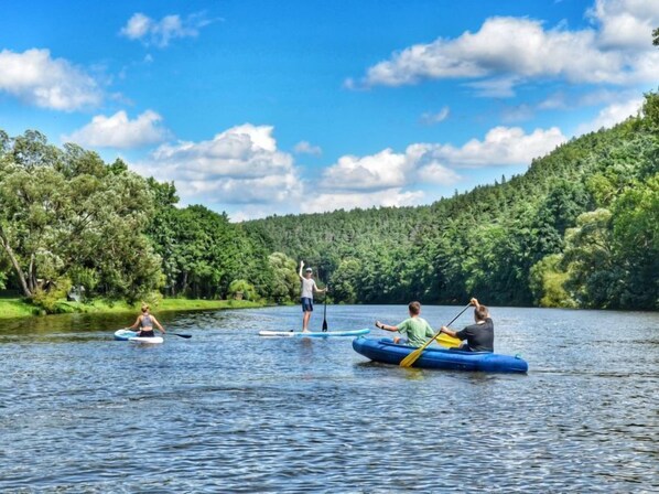 A group of people on a calm river surrounded by lush greenery.