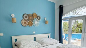 Ein Schlafzimmer mit einem großen Bett, einem Nachttisch und dekorativer Wandgestaltung.