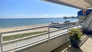 A balcony with a view of the sea and a distant cityscape. - Larmor-Plage 1BR with Terrace and Garage (Larmor-Plage)