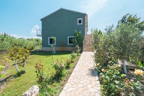 Un edificio a due piani con un vialetto in pietra che conduce all'ingresso.