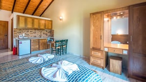 A room with a kitchen, a dining area, a bed, and a wooden wardrobe. - 'Mirage Arillas Studio Type C18' with Shared Pool & Wi-Fi (corfu)