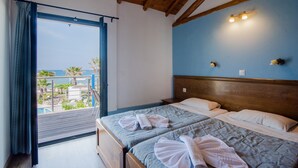 A room with a wooden ceiling, a bed with two pillows, a headboard, and a view of a pool and palm trees. - Pet-Friendly Apartment 'Mirage Arillas Maisonette B' with Sea View, Shared Pool & Wi-Fi (corfu)
