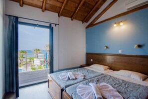 A room with a wooden ceiling, a bed with two pillows, a headboard, and a view of a pool and palm trees.