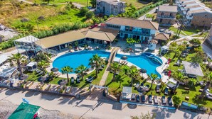 Vista aèria d'un complex hoteler amb una gran piscina, diverses zones de relaxació i diferents tipus d'allotjament.