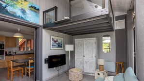 A modern interior with a dining area, a television, a white wardrobe, and a sofa. - Villa with Stunning Views, Terrace and Garden (Moliets-et-Maa)