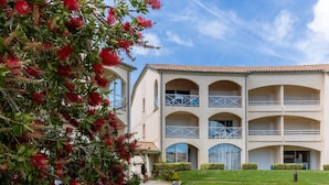 A multi-story building with a symmetrical facade, large windows, and a central courtyard. - T3 with Heated Pool, Private Garden, and Golf Nearby – Moliets (Moliets-et-Maa)