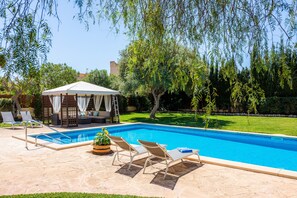 A swimming pool with lounge chairs, a gazebo, and a well-maintained lawn. - Villa 'Rico' with Mountain View, Pool & Wi-Fi (Portocolom)
