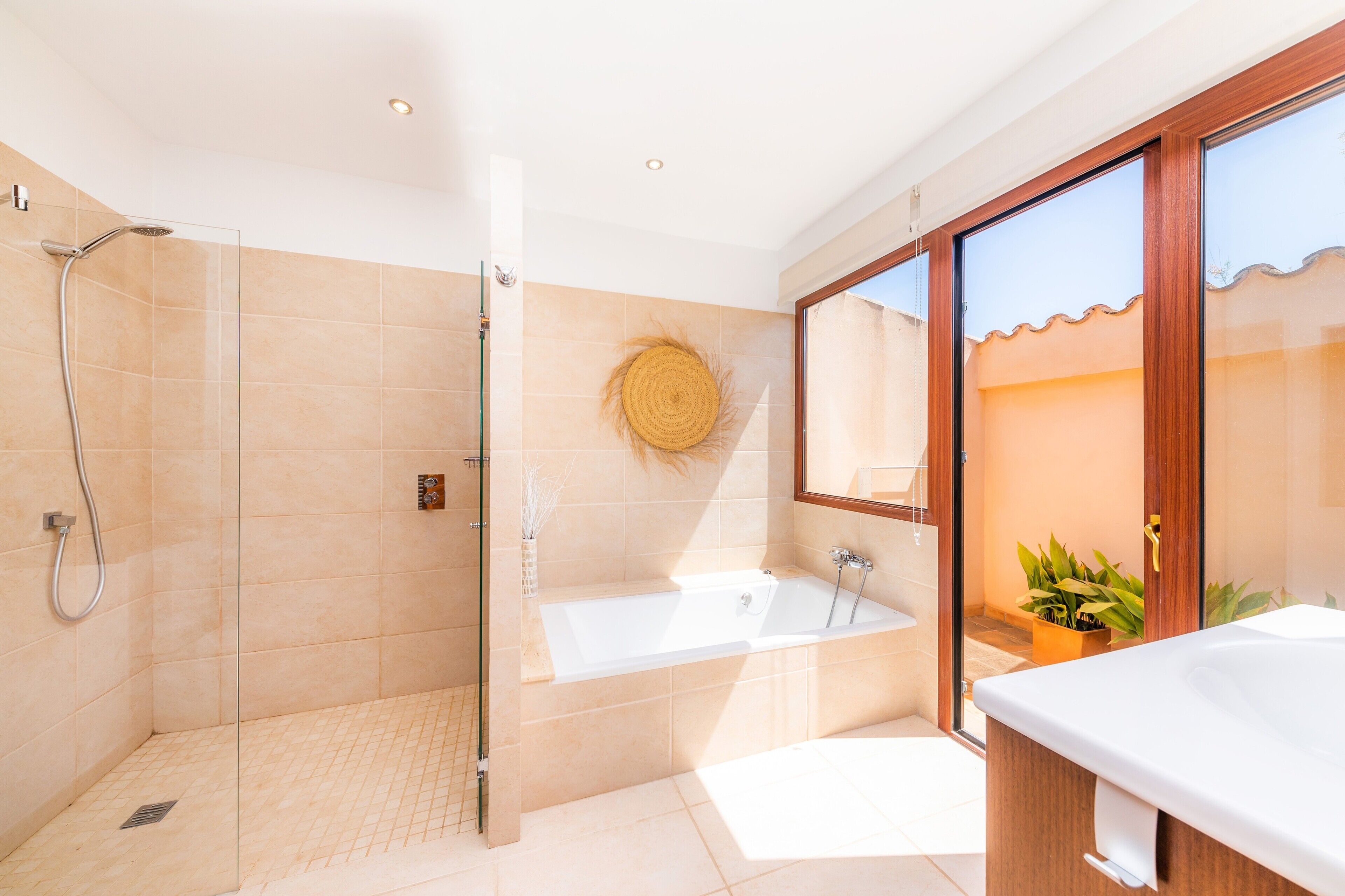 A modern bathroom with a glass-enclosed shower, a freestanding bathtub, and a large mirror.