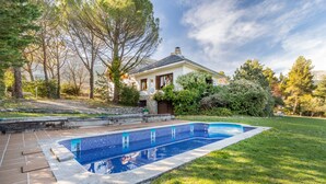 A house with a swimming pool, surrounded by a well-maintained lawn and trees. - Yoar Holiday Home with Mountain Views and Wi-Fi (Sant Llorenc de Morunys)