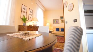 A dining area with a round table, chairs, a lamp, and a plant. - CAsa Ri al mare (Genova)