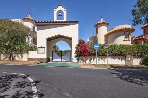 A building with a bell tower, an archway entrance, and a street sign. - Luxury villa with private pool (Islantilla)