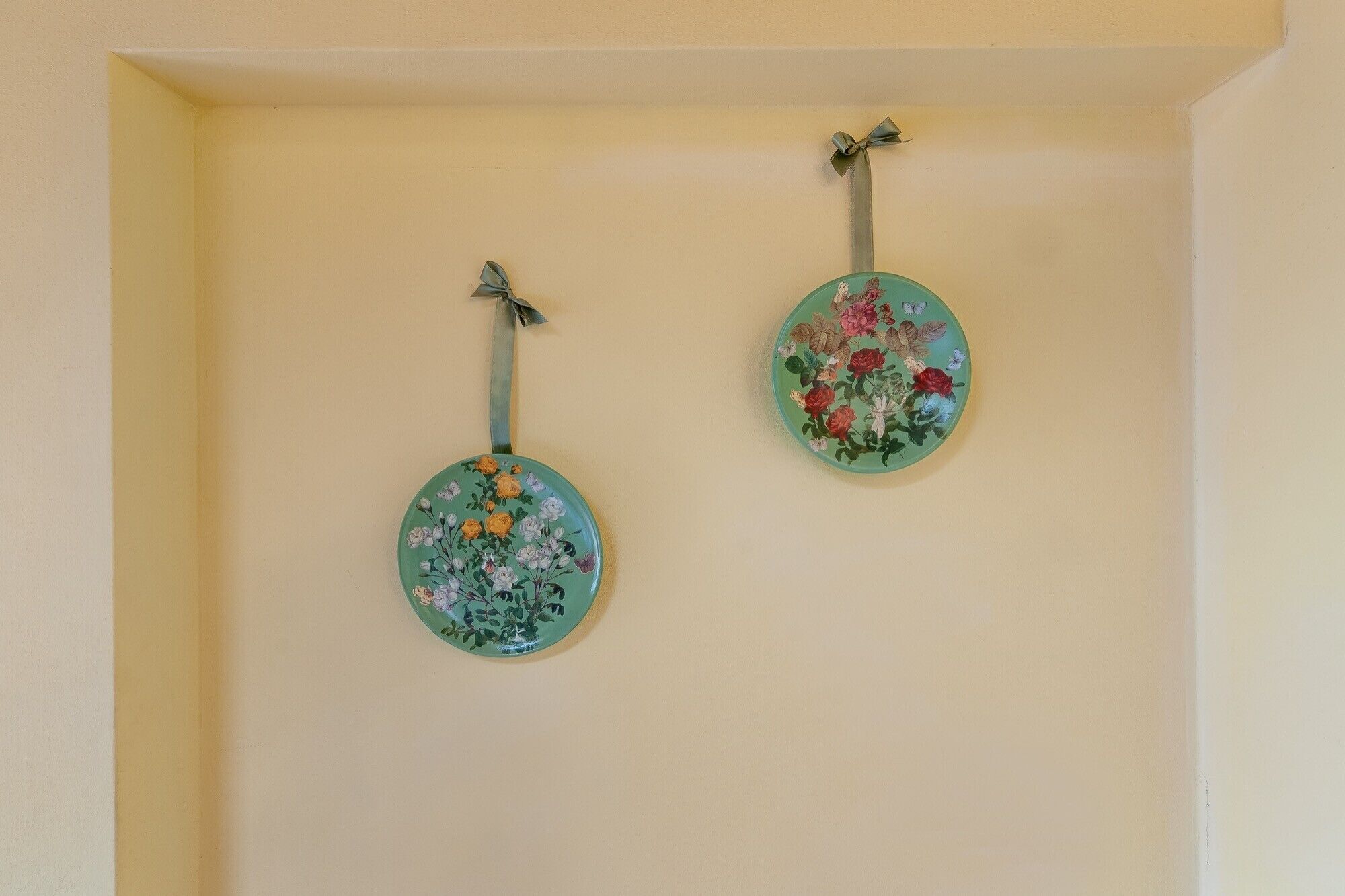 Dos placas decorativas colgadas en la pared con motivos florales.