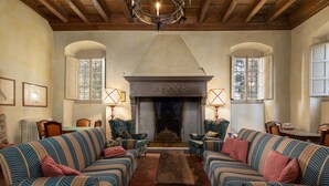 A room with a fireplace, two sofas, a table, and two lamps. - Villa Milani with Shared Pool, Private Terrace & Wi-Fi (Montespertoli)