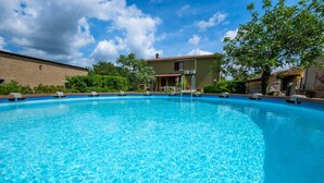 A clear blue swimming pool with lounge chairs and a building in the background. - Pet-Friendly Holiday Home Fonte Etrusca with Pool, Garden & Wi-Fi (sorano)