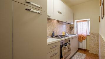 A kitchen with a stove, oven, and cabinets.