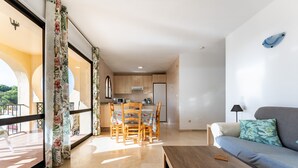 Uma sala de estar moderna com um sofá, uma mesa de centro e um espaço de jantar com cadeiras e uma mesa.