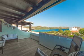A covered outdoor seating area with a view of the sea and hills. - Apartment 'La Terrazza sul Mare' with Sea View, Terrace and Wi-Fi (Palau)
