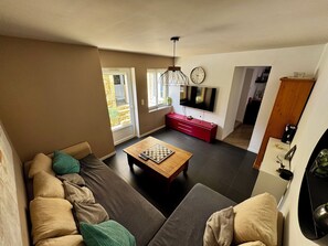 A modern living room with a sofa, a coffee table, a TV, and a fireplace.