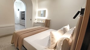 Une chambre à coucher avec un lit, une table de chevet, un miroir et une armoire.