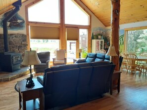 Cozy living area with a fireplace, dining table, and mountain mural.