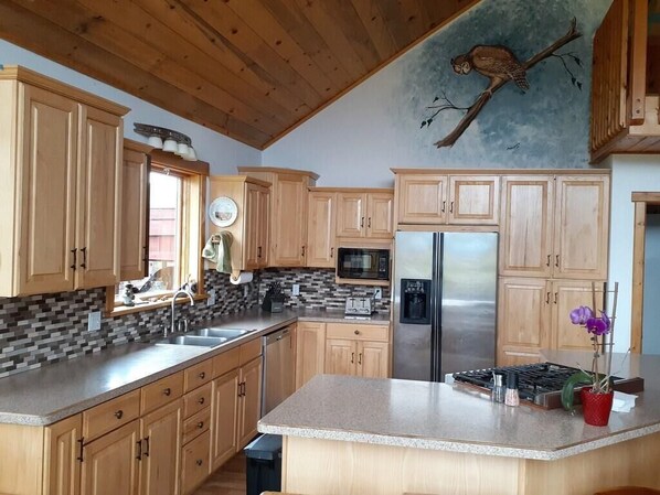 Enjoy cooking in this well-equipped kitchen with a central island, gas stove, and refrigerator.