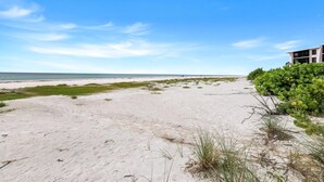 Une plage avec un bâtiment et de la végétation.