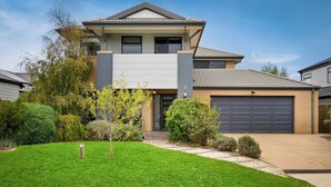 A modern two-story house with a garage, surrounded by well-maintained lawns and shrubs. - Boobook Retreat in Cowes (Cowes)