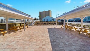 A covered outdoor area with picnic tables and solar panels on the roof.