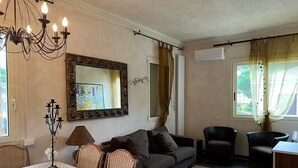 A cozy living room with a sofa, chairs, a table, and a chandelier. - Villa MIMA with garden on two floors, 100 m from the sea. (Milano Marittima)