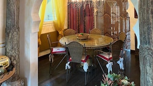 A dining area with a round table, chairs, and a chandelier. - Villa MIMA with garden on two floors, 100 m from the sea. (Milano Marittima)