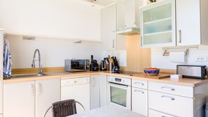 A modern kitchen with white cabinets, a microwave, a toaster, and a sink. - 450 m from the beach – House for 6 – Garden & BBQ (Treffiagat)