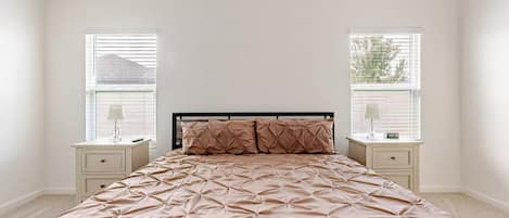 Ein Schlafzimmer mit einem Bett, zwei Nachttischen und einem Fenster.
